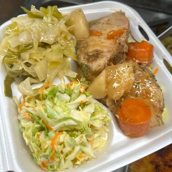Southern-style meat and three with sliced pork, stewed cabbage, coleslaw, potatoes, and carrots.