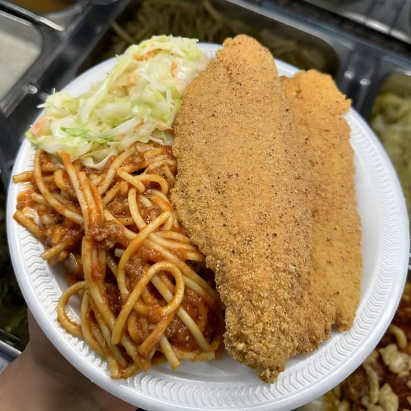 A Ramzys Meat & Three plate with fried fish, spaghetti with meat sauce, and coleslaw.
