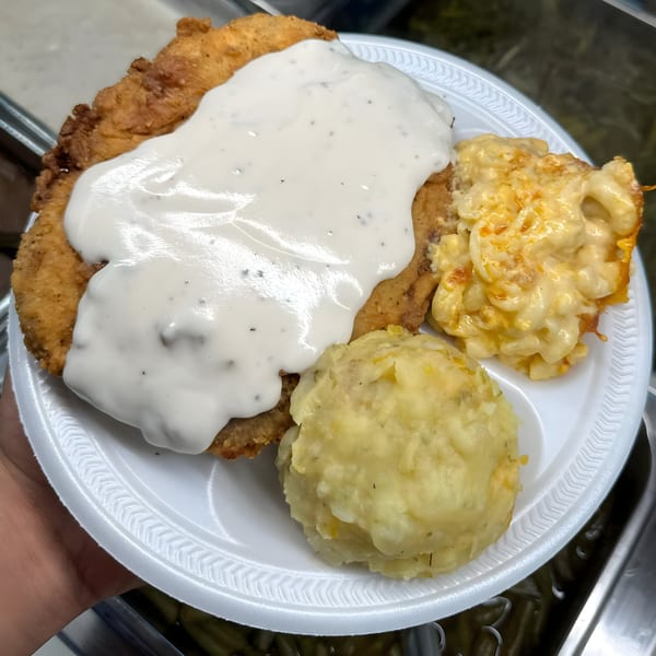 Ramzys Meat & Three's chicken fried steak with gravy, macaroni and cheese, and mashed potatoes.